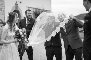 Les invités s'amusent dans le voile de la mariée